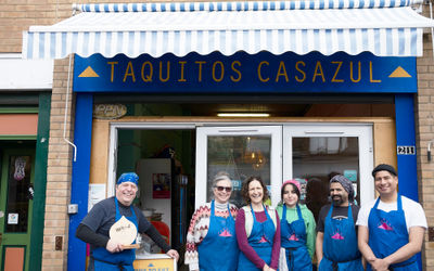 The team at Casazul celebrating their BRAVO award in front of the bright blue restaurant. Located at Brighton Open Market