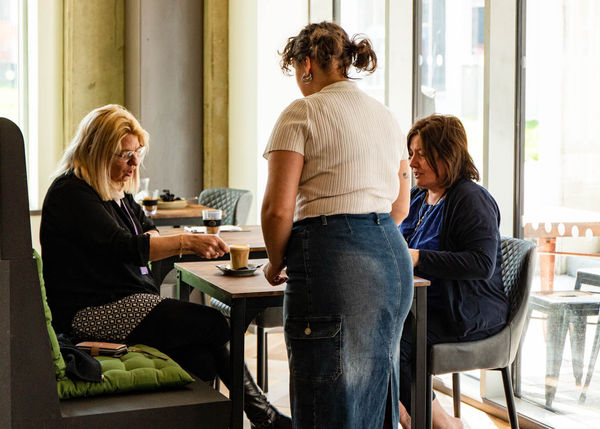 People sat at the table with a waitress delivering coffee