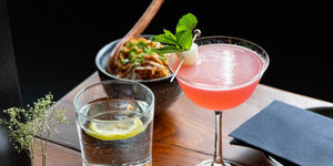 pink cocktail and water with lemon on the table. Included in our Brighton vegetarian restaurants guide.