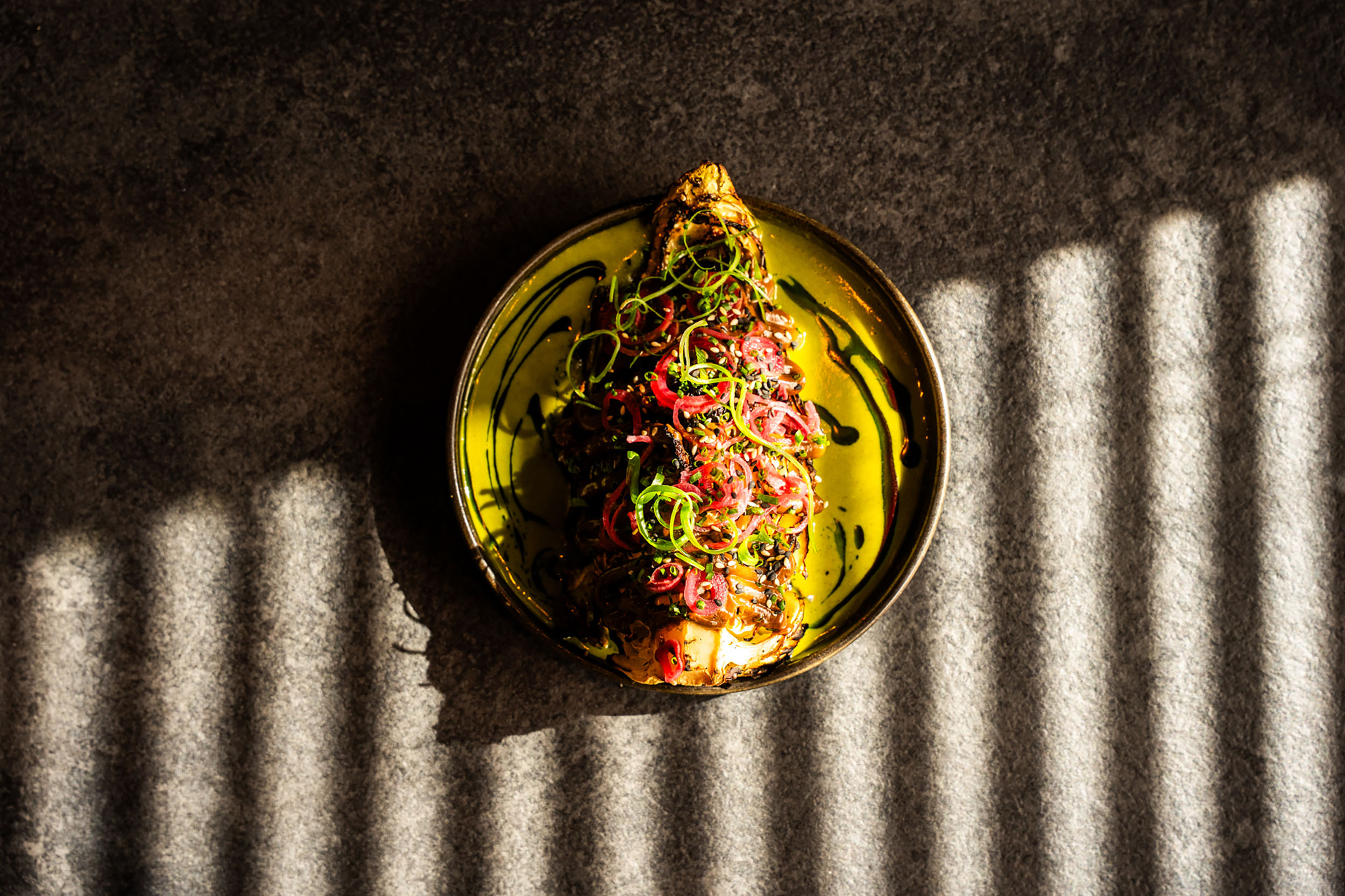 over head shot of the vegan eggplant dish covered in spices and green sauce