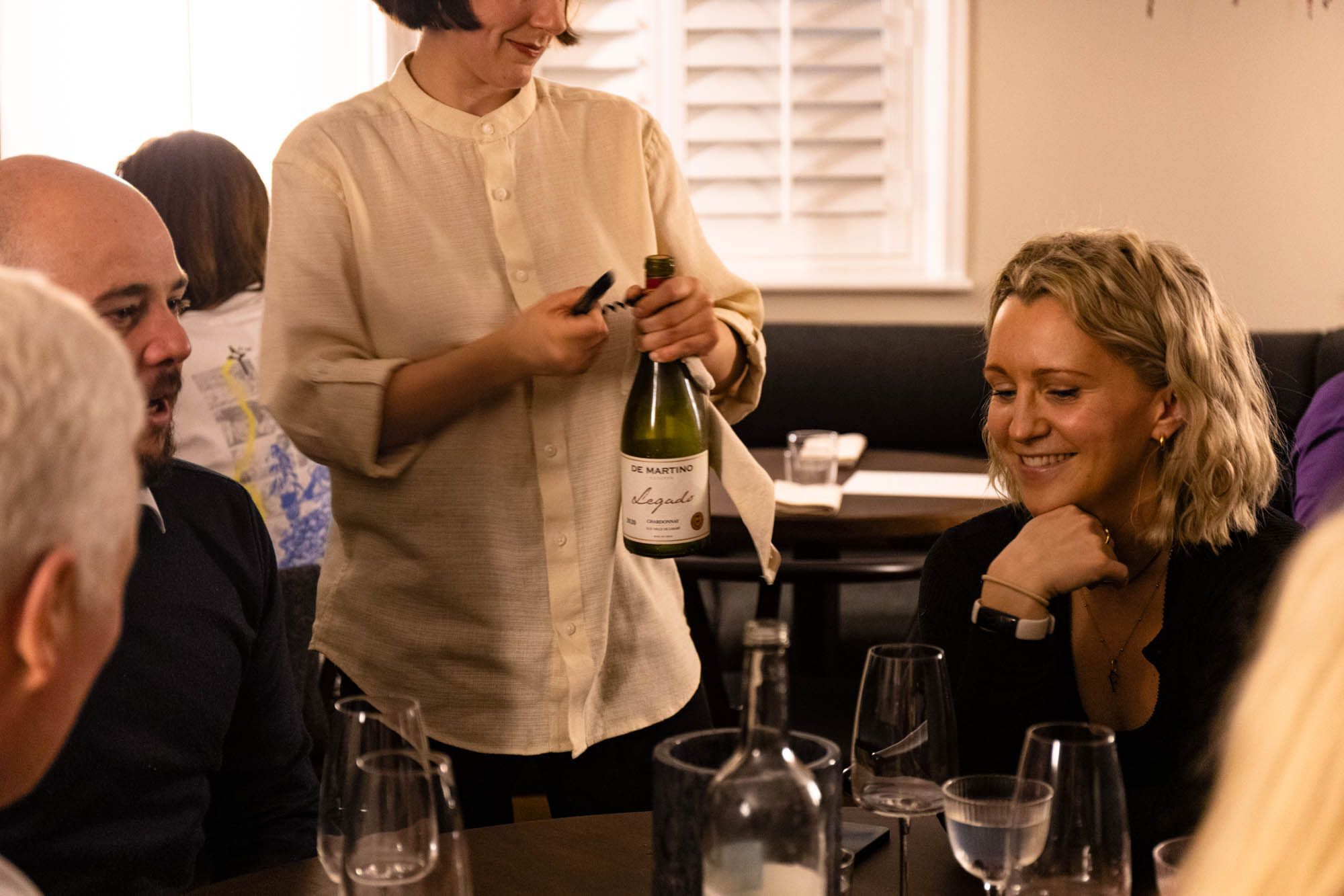 bartender opening wine in front of the guests at Dilsk