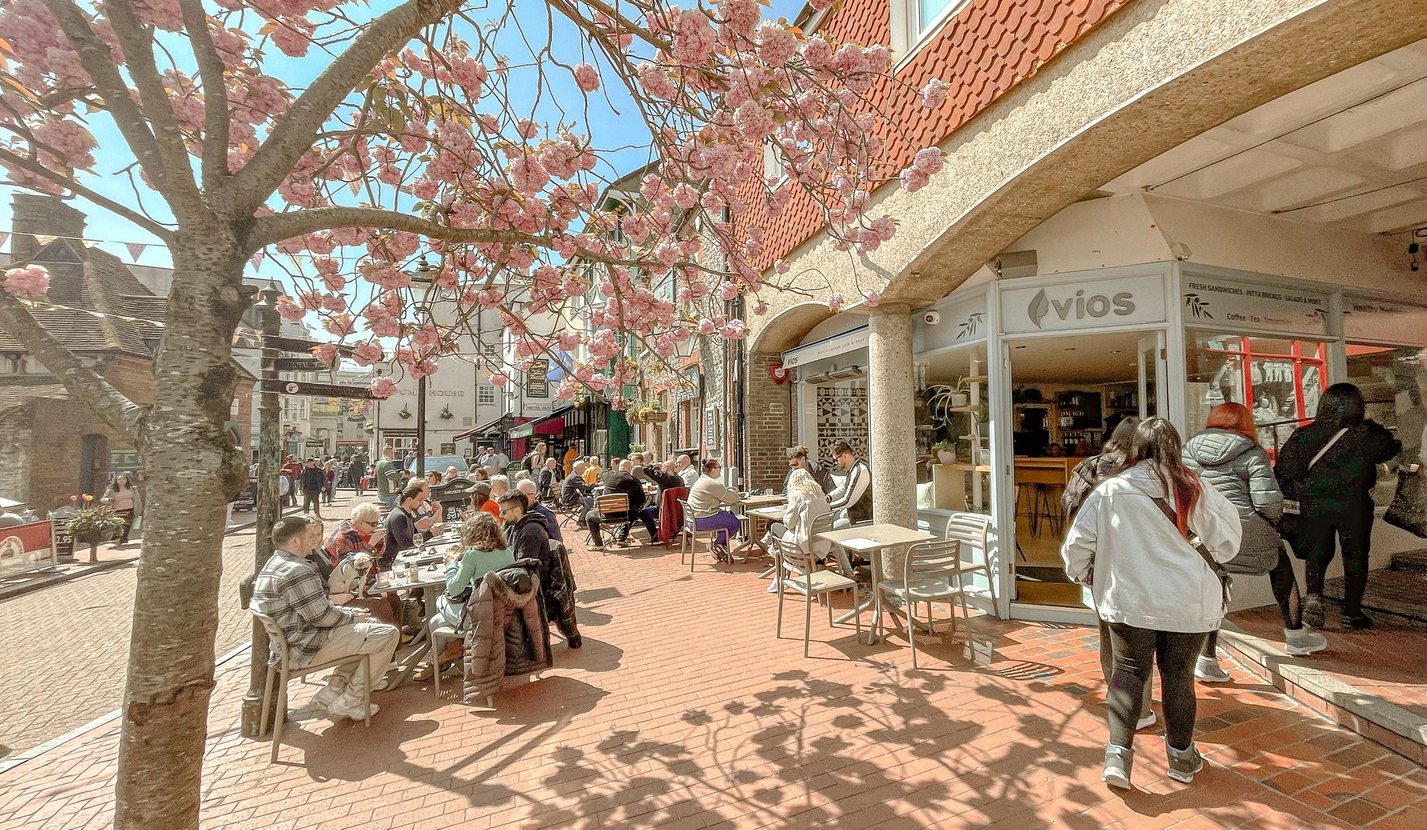 exterior shot of the Vios Brighton cafe and their outdoor seating with people.