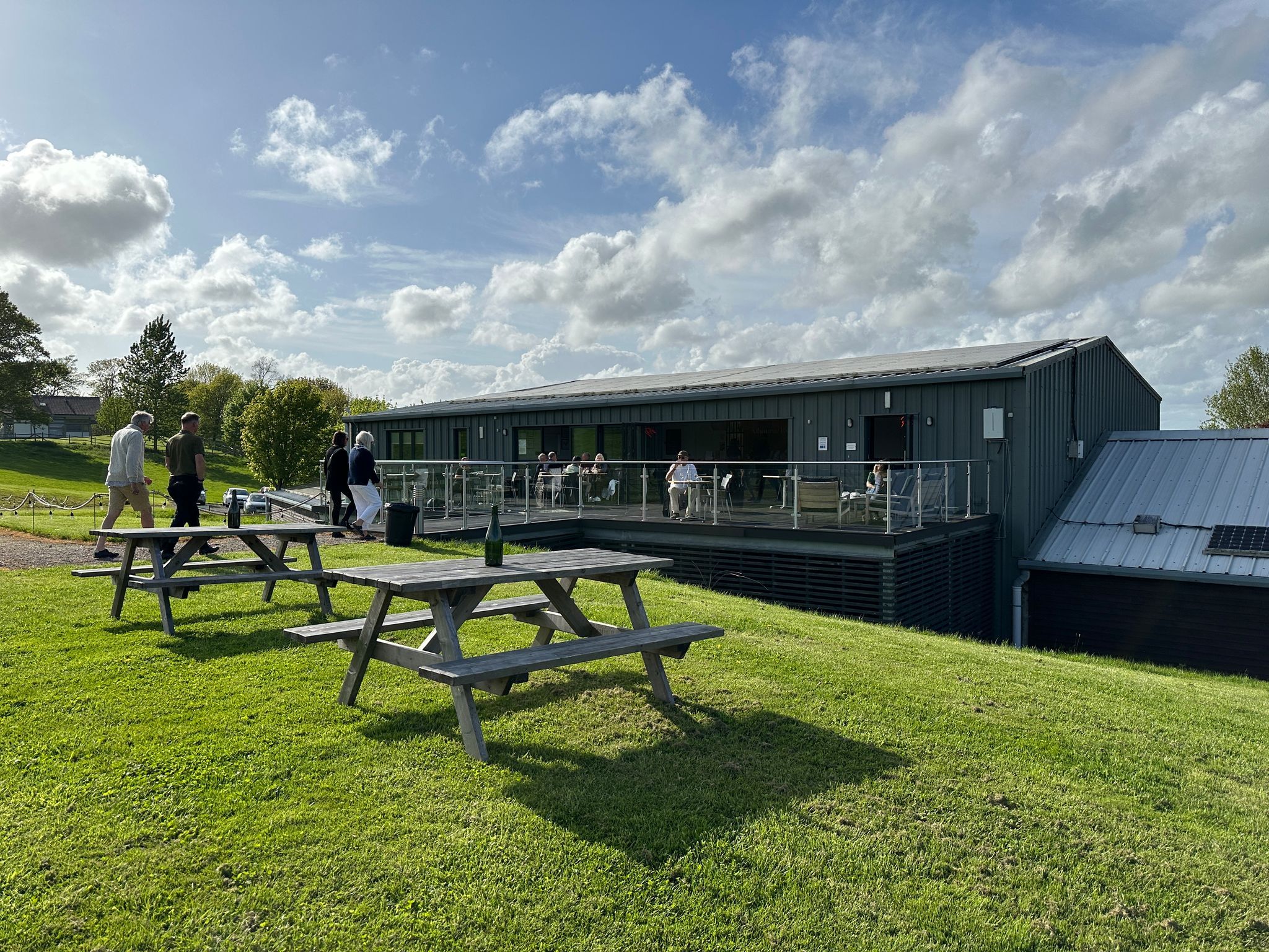 Albourne Wine Estate exterior shot of the green garden and benches ready for the Friday Night Supper Club