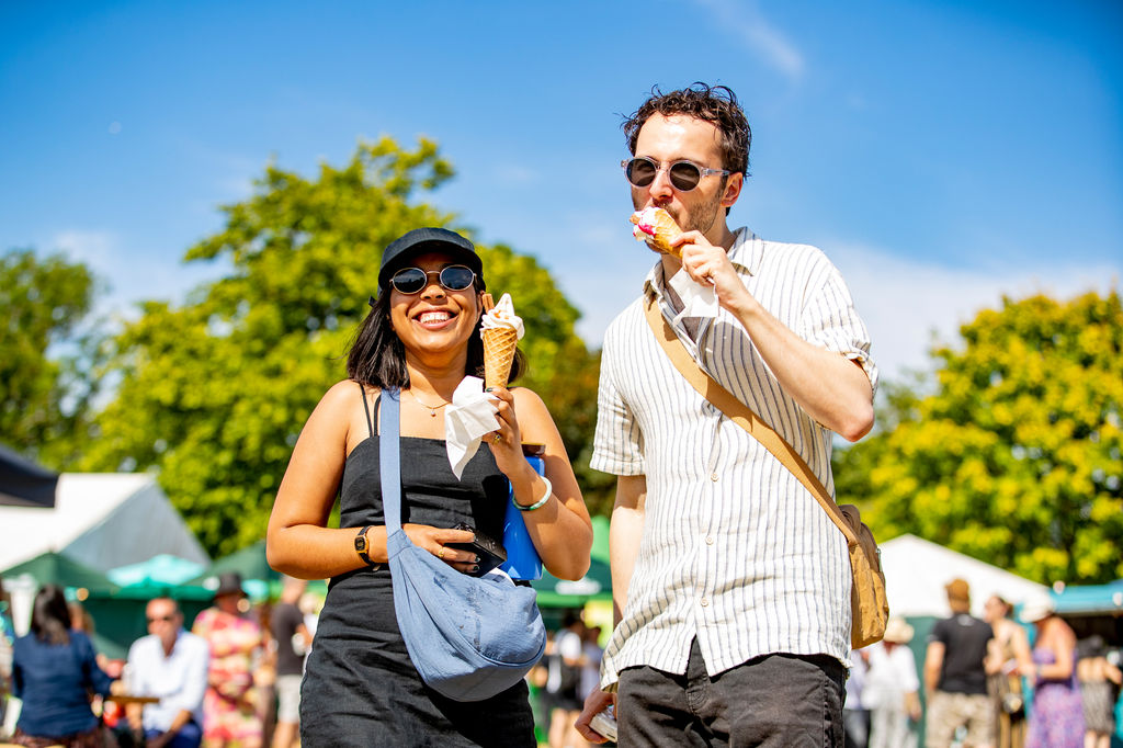 a man and a women in nice summer clothes enjoying their ice creams at the Brighton Comedy Garden