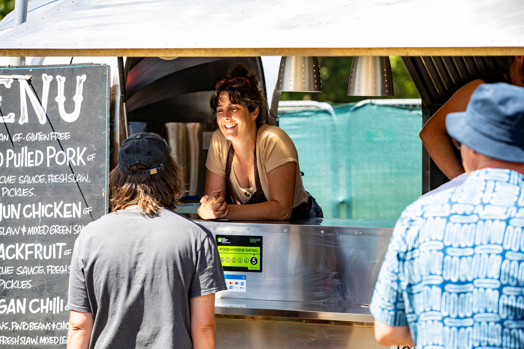 lady at the food truck talking to the customers