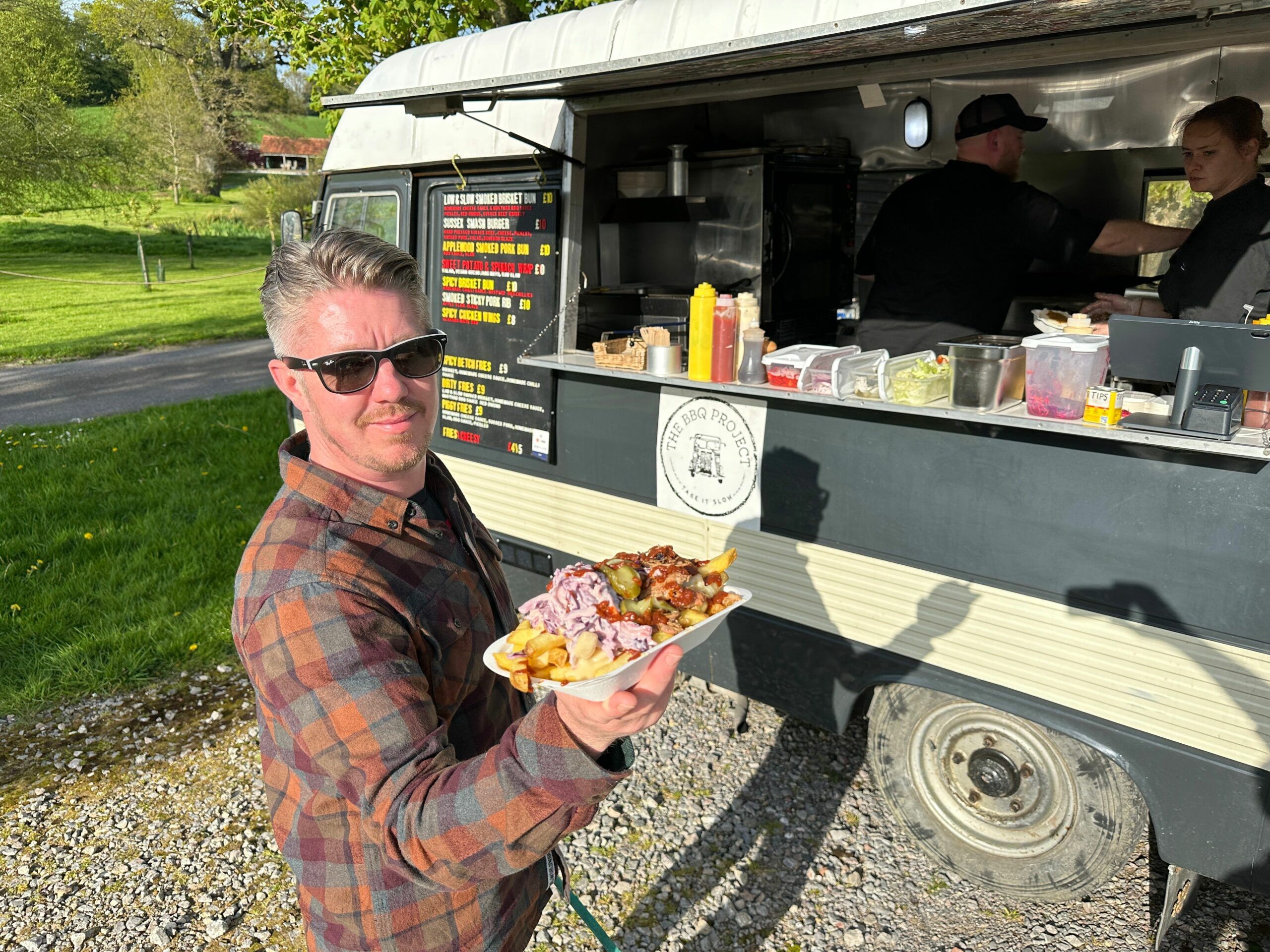 Torsten's friend holding delicious food in the plate at the Supper Club at Albourne Estate