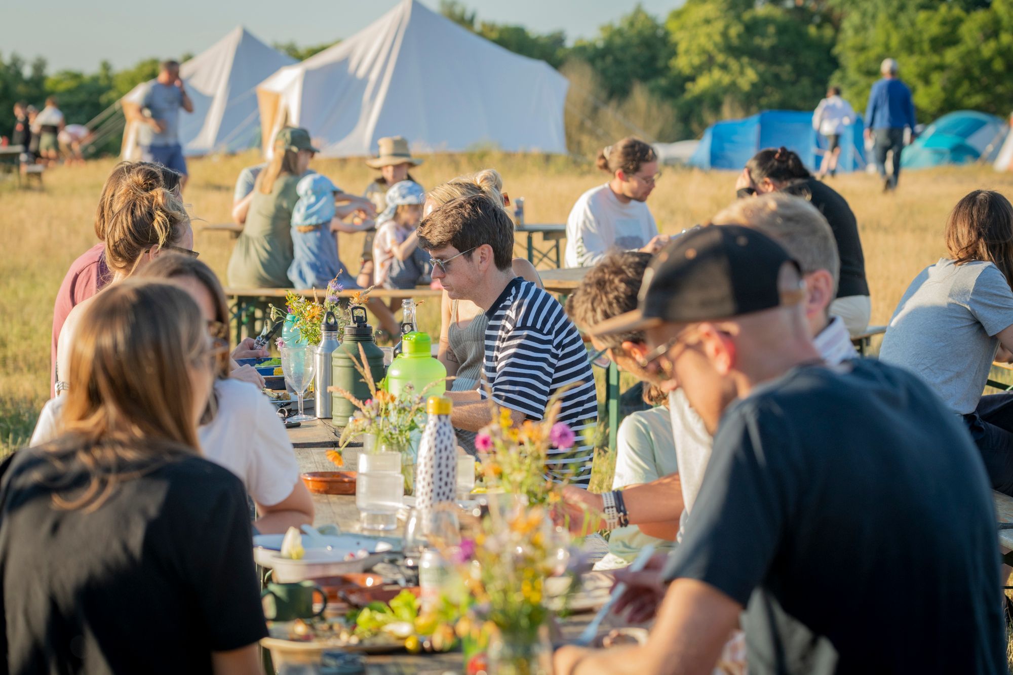 people sitting at the table and enjoying their food at Woodfire Camping