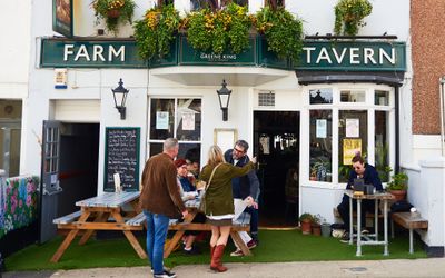 exterior shot of the Farm Tavern in Hove. People greeting each other in front seating area. roast at the farm