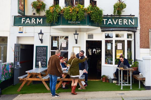 exterior shot of the Farm Tavern in Hove. People greeting each other in front seating area. roast at the farm