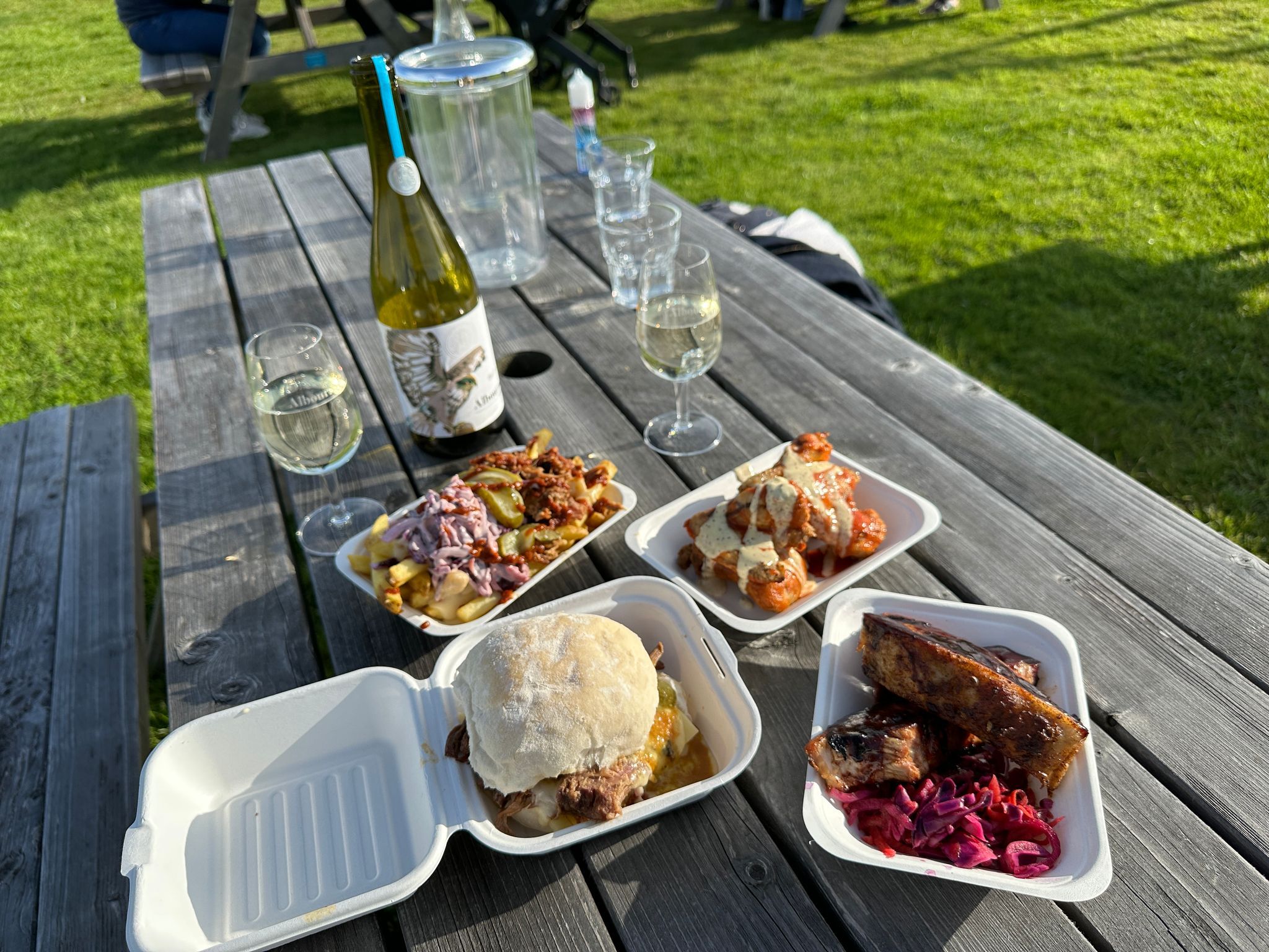 outdoor table at the Albourne Estate with four different types of food and wine