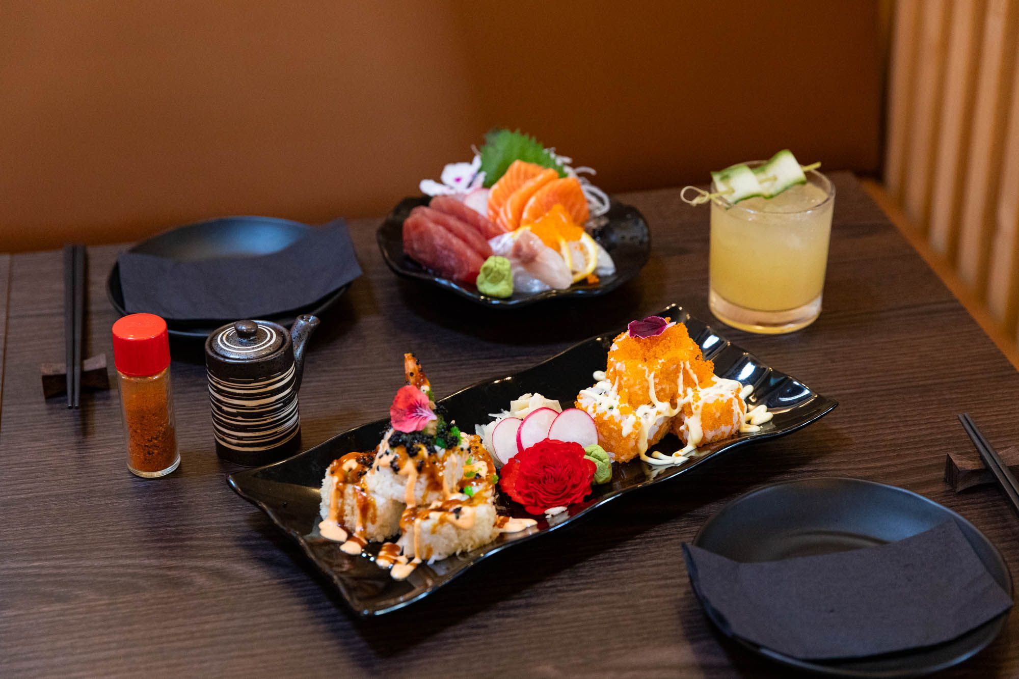 table laid out for two with Japanese food on black plates