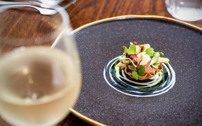 close up shot of the dish and glass of wine at the fig tree. Sussex Tasting menu