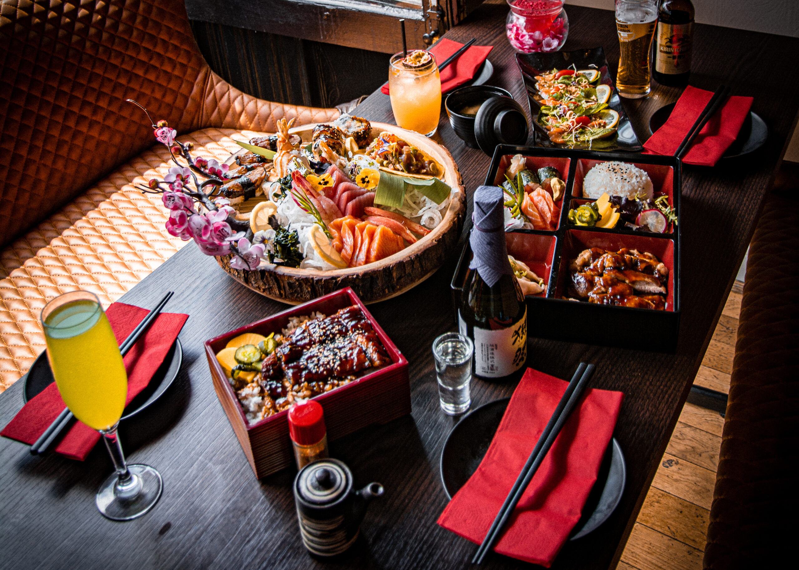 A selection of Japanese food at the restaurant Wabi Sabi, served on a dark wooden table.