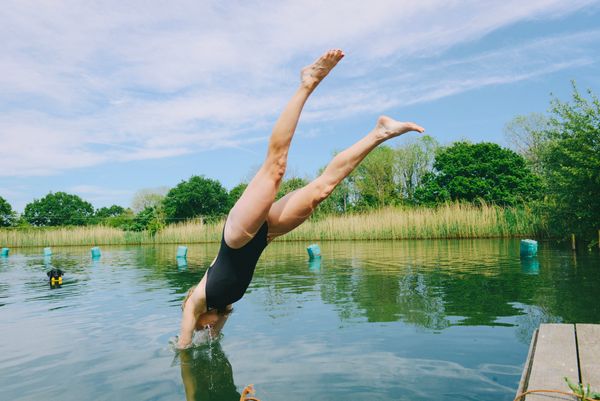 A person diving into a lake on a sunny day.