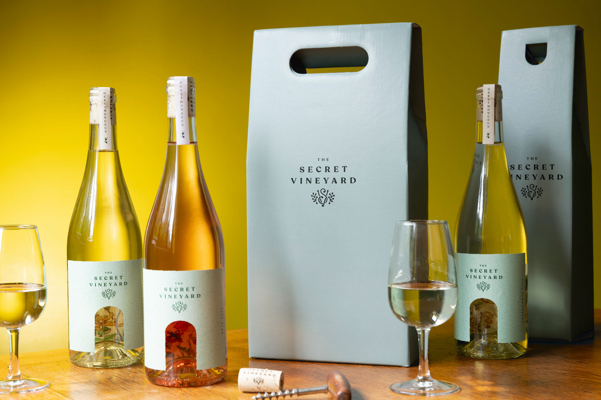 Bottles of wine and packaging photographed against a yellow wall.
