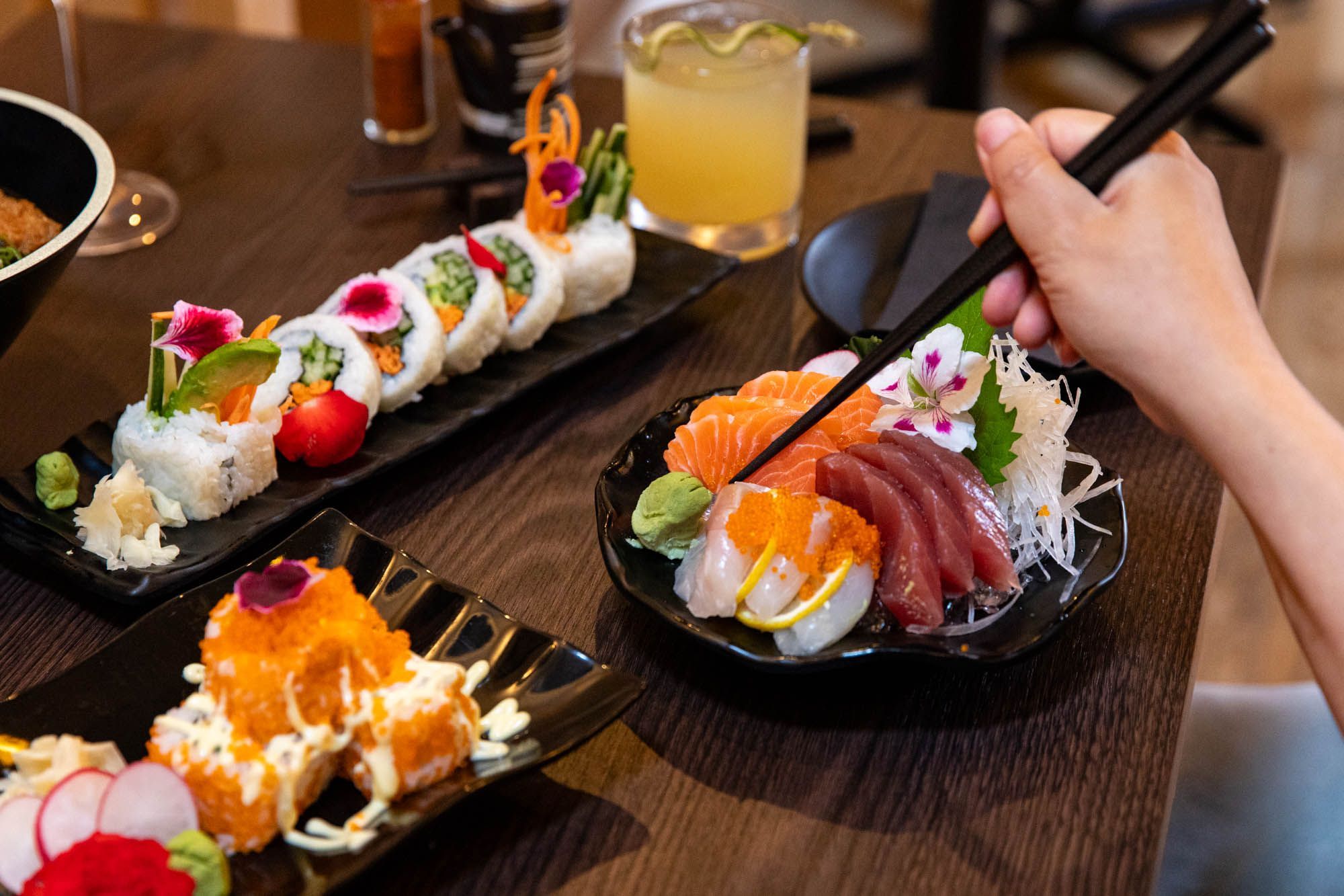 hands using chopsticks to take salmon from the black bow, Wabi Sabi