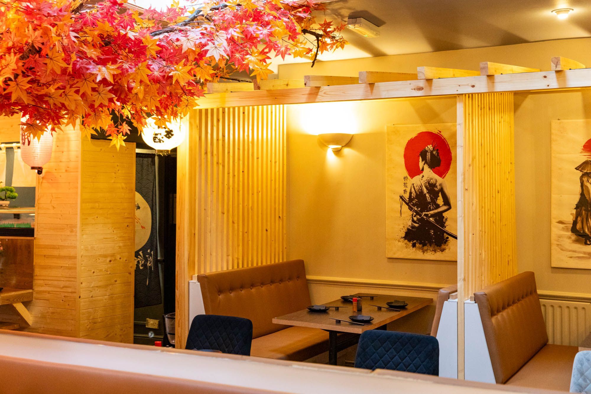 interior shot of Wabi Sabi, yellow walls and dim lights, tree with red and orange leaves