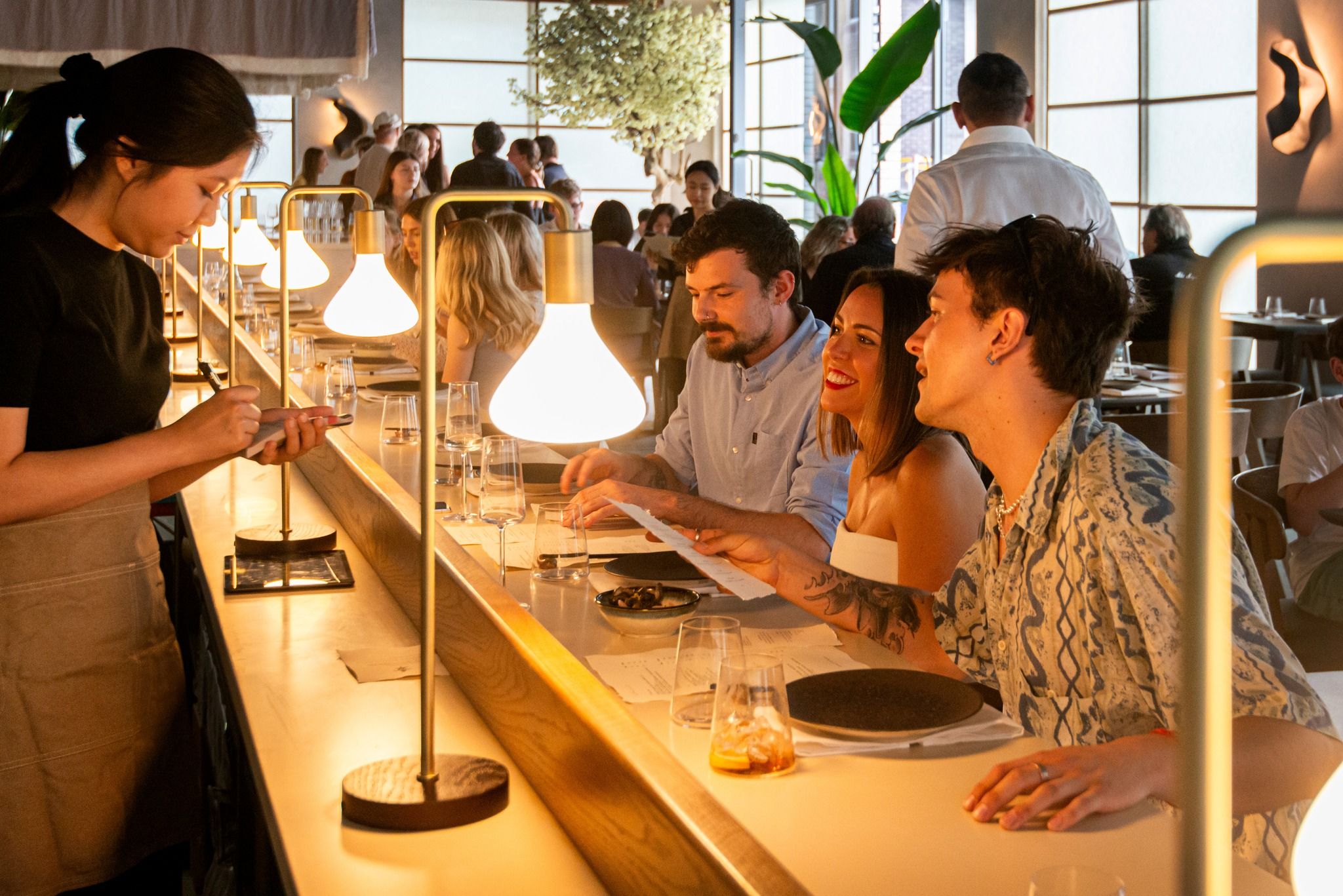 people sitting at the bar area of FUMI restaurant