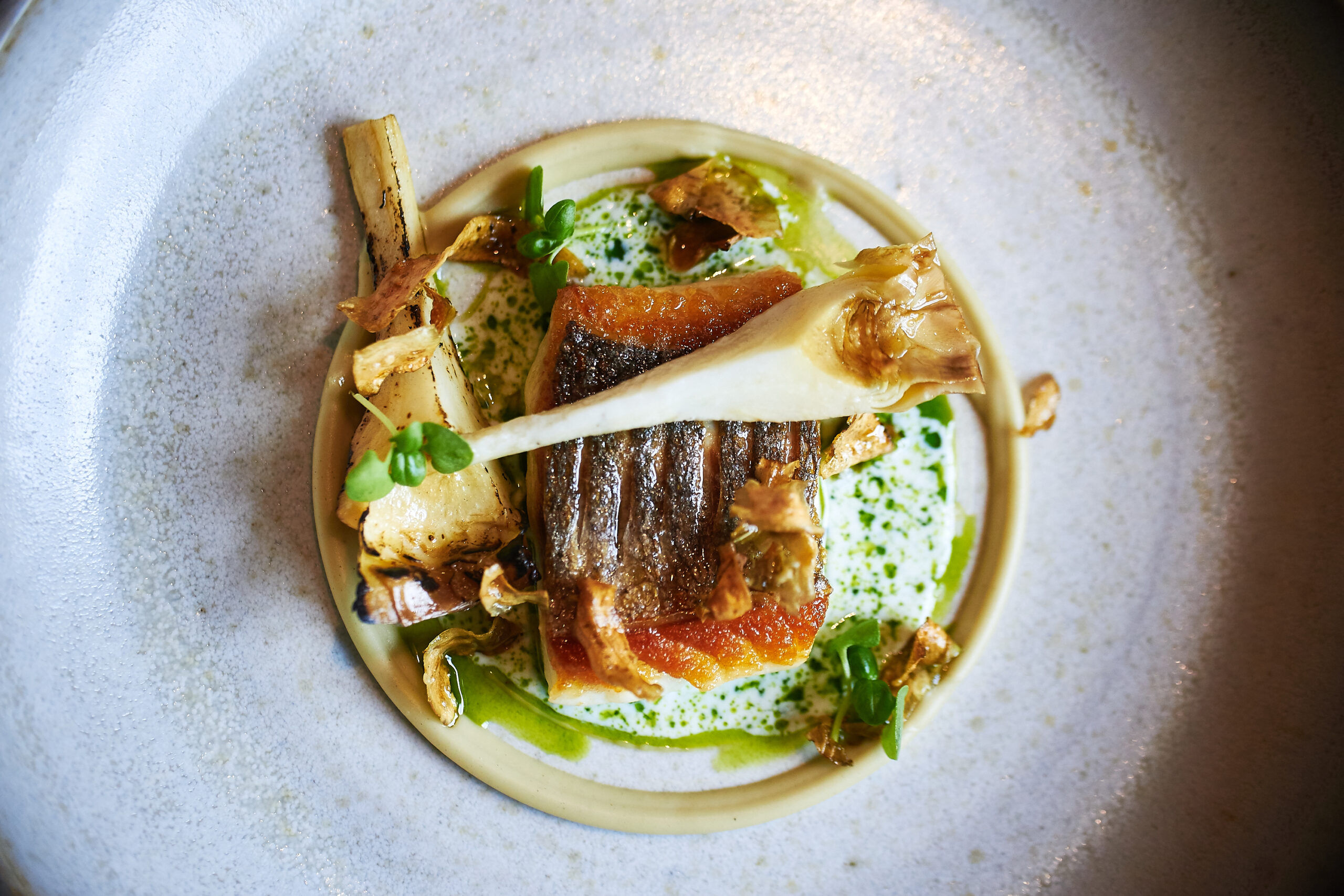 Fish at etch. part of the four-course lunch, carefully displayed on a white ceramic plate.