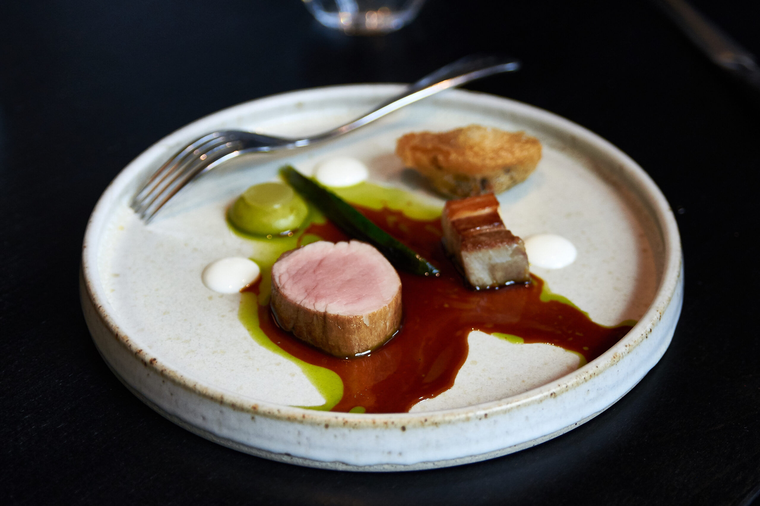 Pork served at etch. for the four-course lunch, with a fork sitting on the side of a white ceramic plate.