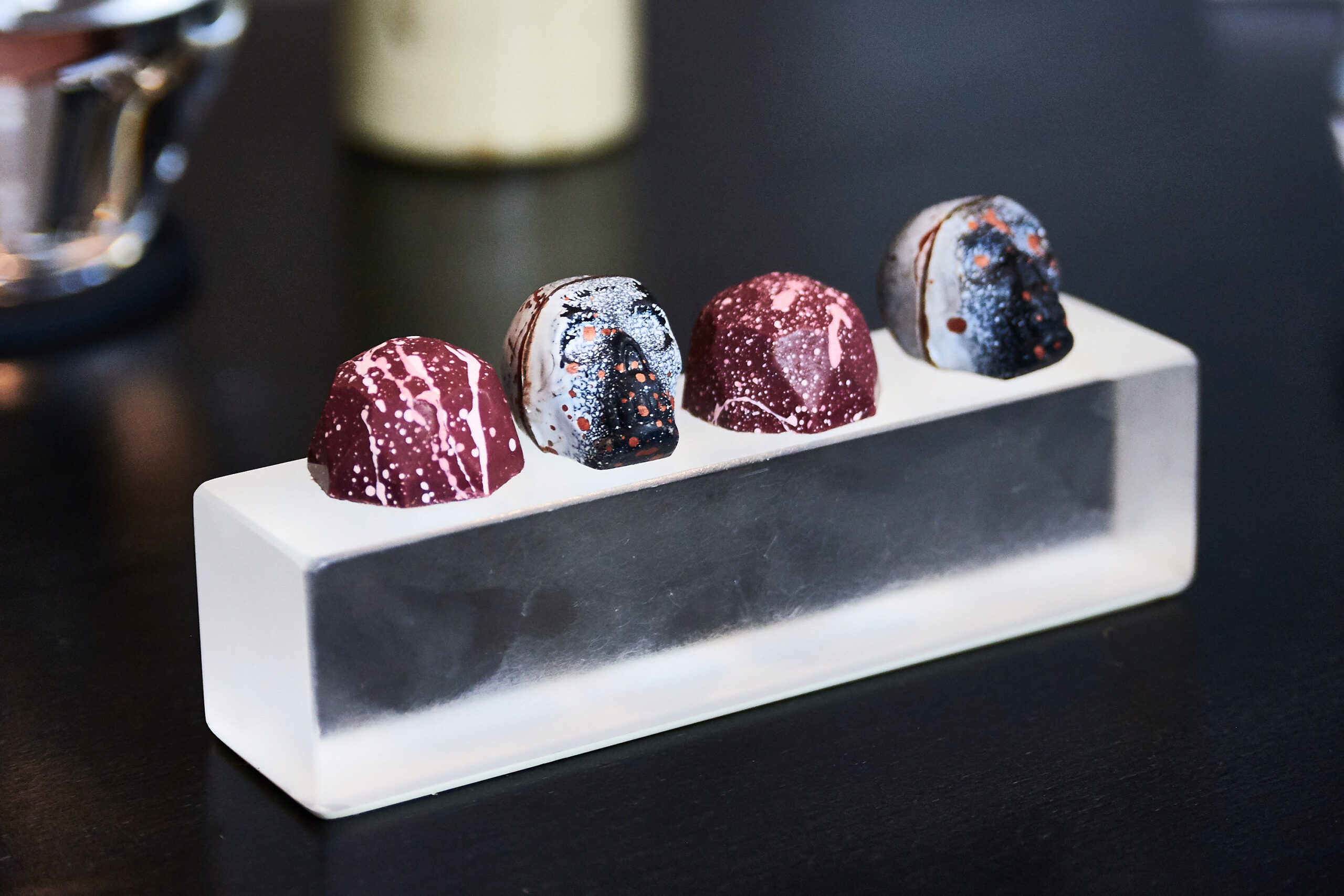 Alcohol infused chocolates in the shape of skulls on a plastic block at etch.
