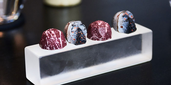 Alcohol infused chocolates in the shape of skulls on a plastic block at etch.