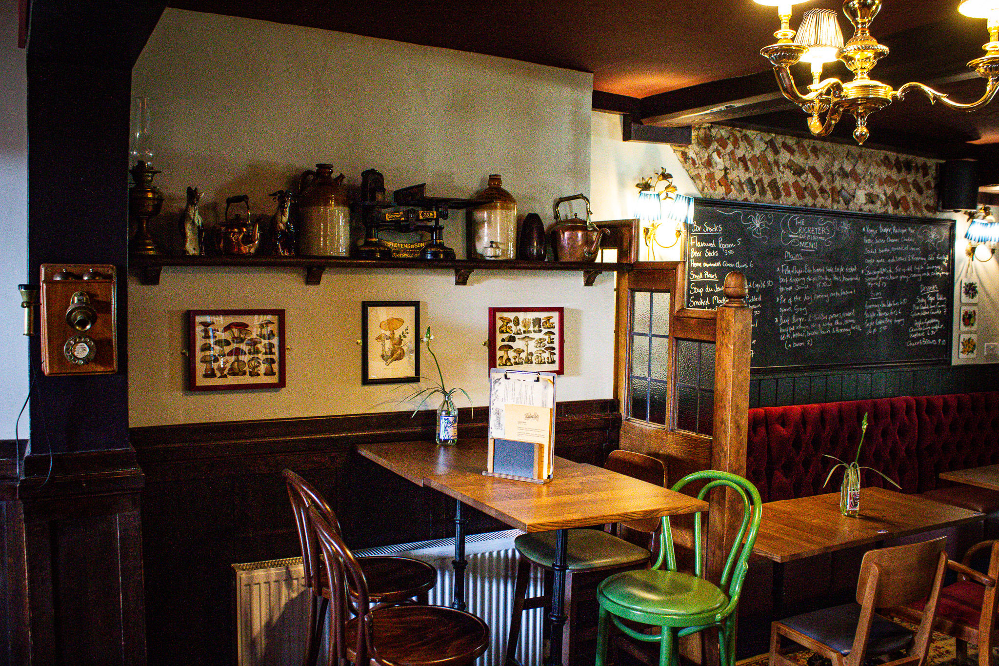 interior shot of the Cricketers Worthing pub in Sussex. Dim lights, brown wooden tables and chairs with decorations on the wall.