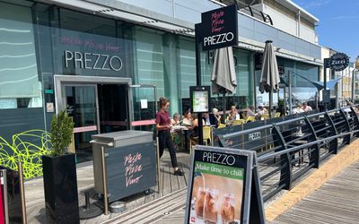 Prezzo Italian restaurant on Brighton marina. Pictured their terrace overlooking the Brighton marina with an A board in the foreground and diners sitting outside.