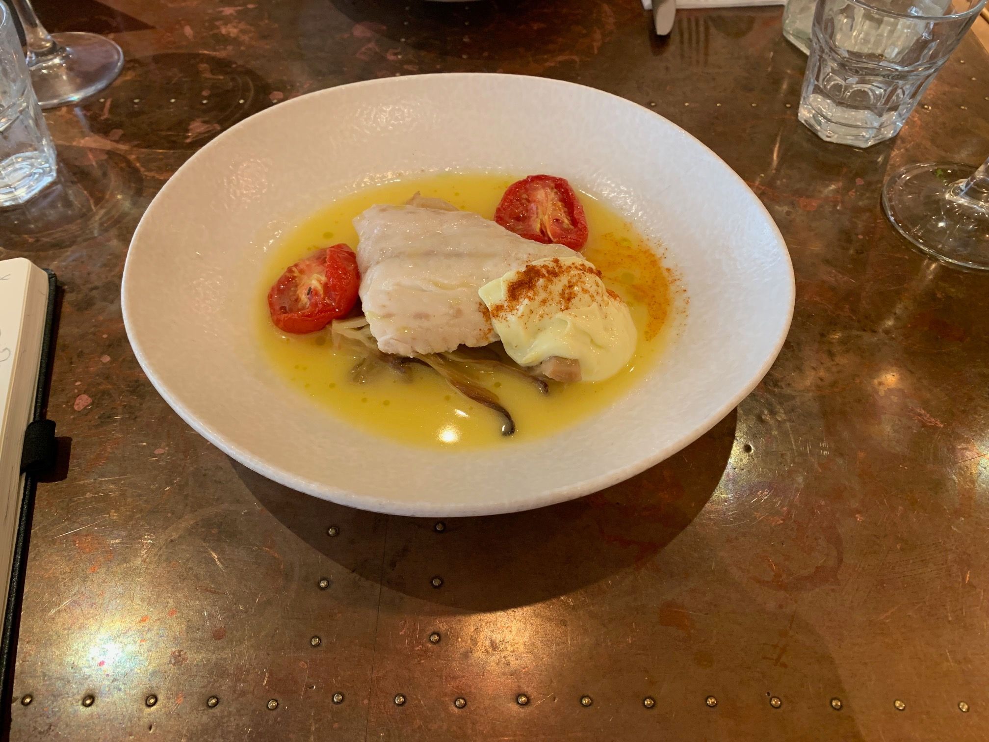 hake dish with tomatoes served in the white plate. Mediterranean treat at Lost in The Lanes