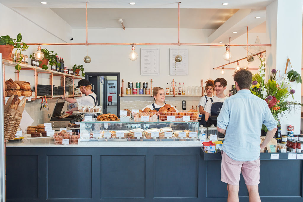 The Flour Pot Bakery in full swing. Smiling staff greeting customers and a shop front with all their artisan breads. Sussex Supplier Directory. the Flour Pot Bakery features very highly in the best cafes in brighton in 2025.