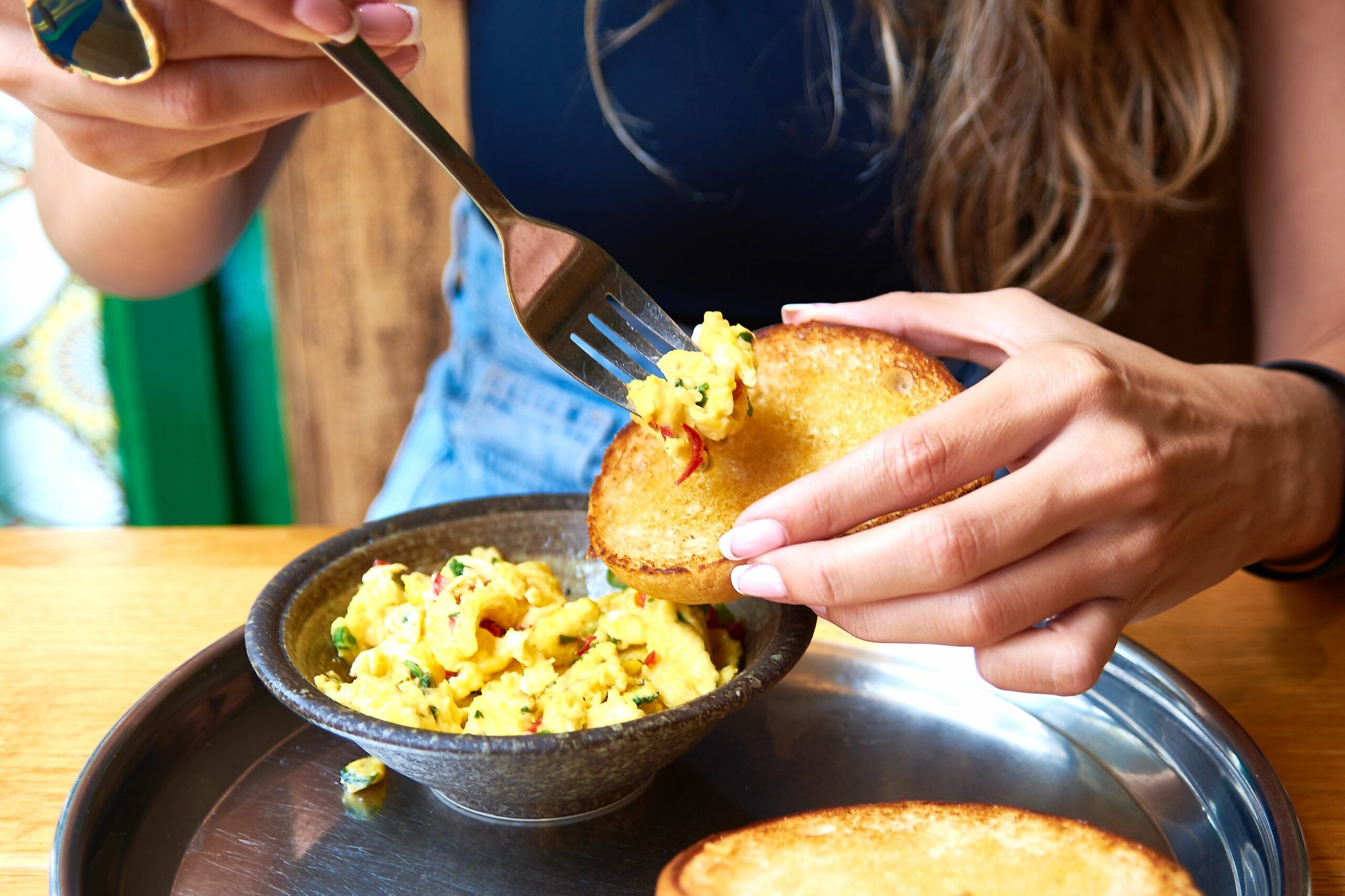 Nico adding scrambled eggs on the bun