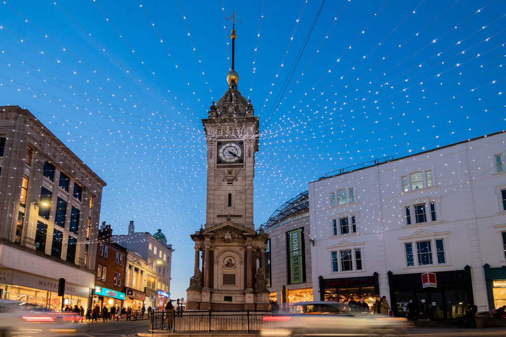 Brighton Christmas Party Menu. Pictured the clocktower in Brighton with bright twinkly lights, a blue sky
