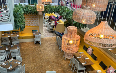 Interior of Jo and Co restaurant taken from the mezzanine with wooden floors and lampshades.