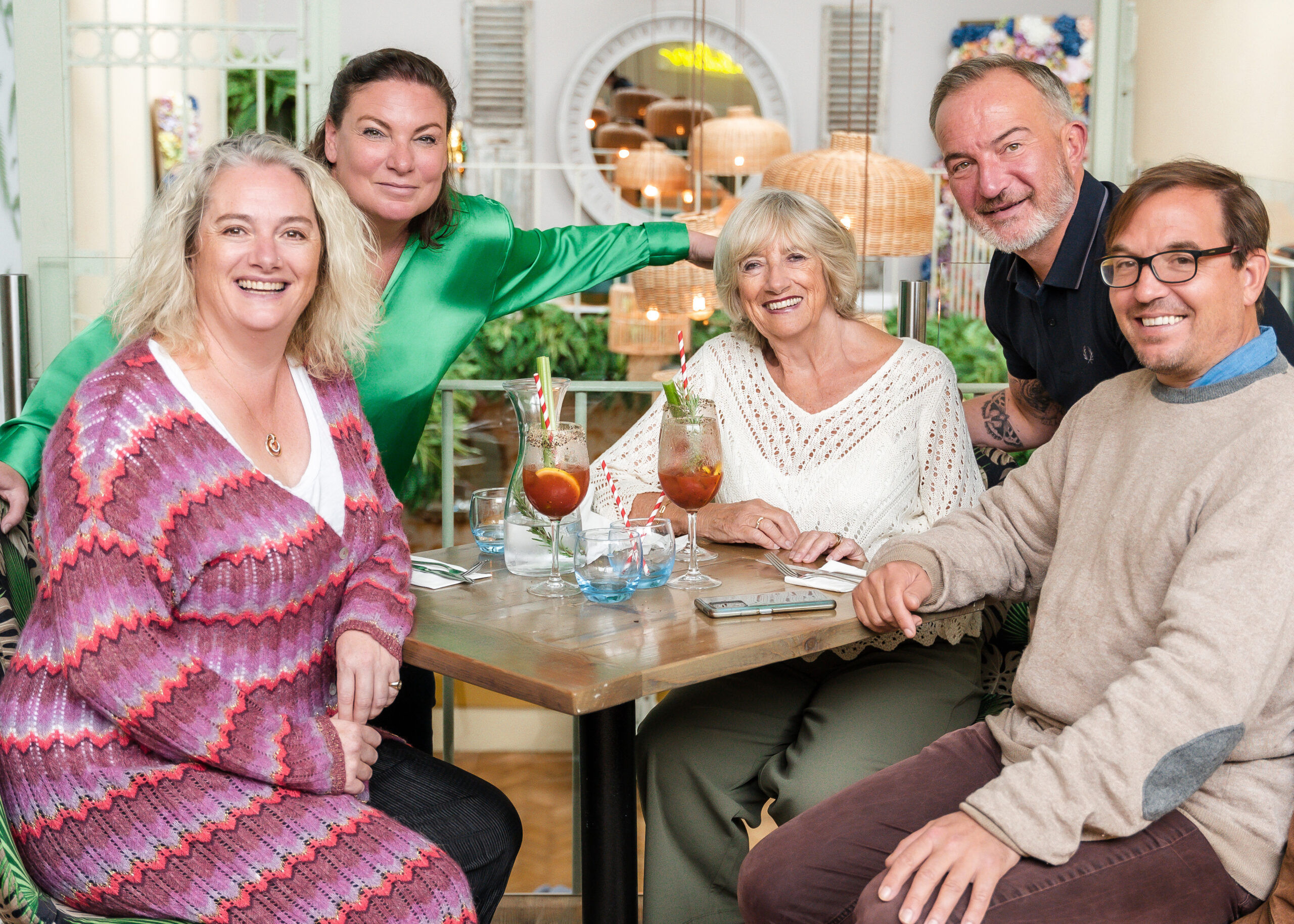 People celebrating with drinks at a table on the mezzanine inside the restaurant.