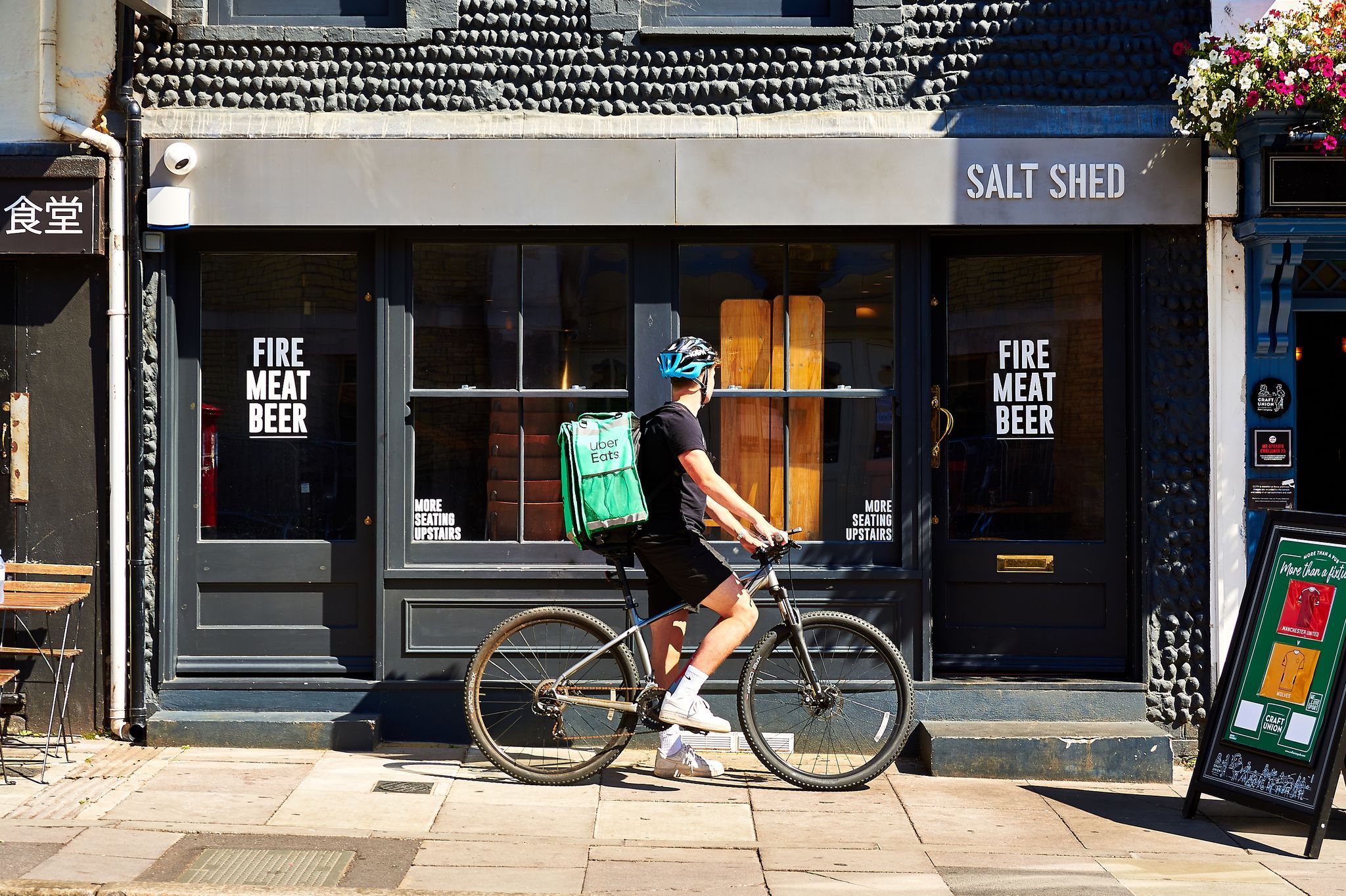 Uber Delivery person on the bike waiting with the uber eats bag in front of the salt shed
