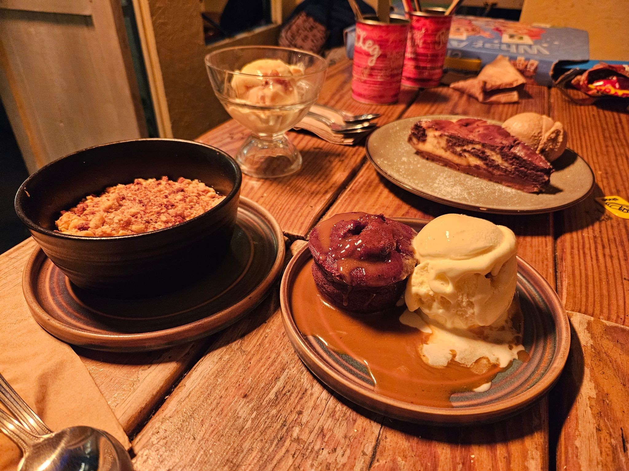 four different desserts at the table including apple crumble, sticky toffee pudding and cheesecake. Fantastic food