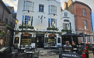 The Cricketers Brighton. a white building which has a vintage style to the left with courtyard seating to the right. Beer tables outside and The Greene Room upstairs. Located in Brighton's historic Lanes. Near to the seafront and Brighton's Royal Pavilion.