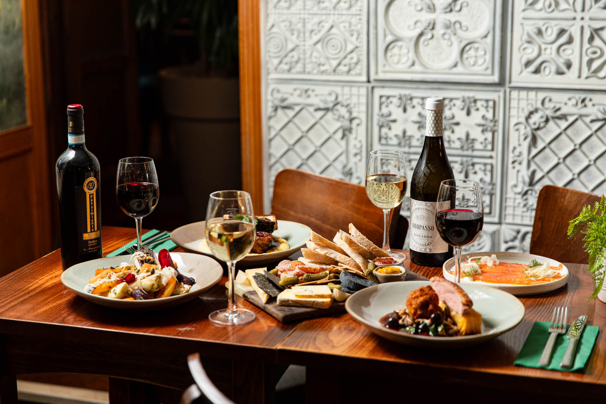 brown wooden table laid out with various dishes and bottle of wines at the Hove Place pub.