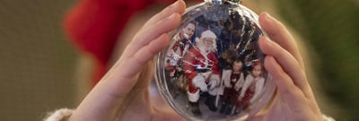 Meet Father Christmas at The Royal Pavilion in Brighton. Santas Grotto experience, Christmas with the kids. Pictured a child holding a baubel in Santas Grotto