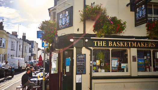 exterior shot of the basketmakers pub on the sunny day, people sitting outside and enjoying their drinks. Located in Brighton North Laine.