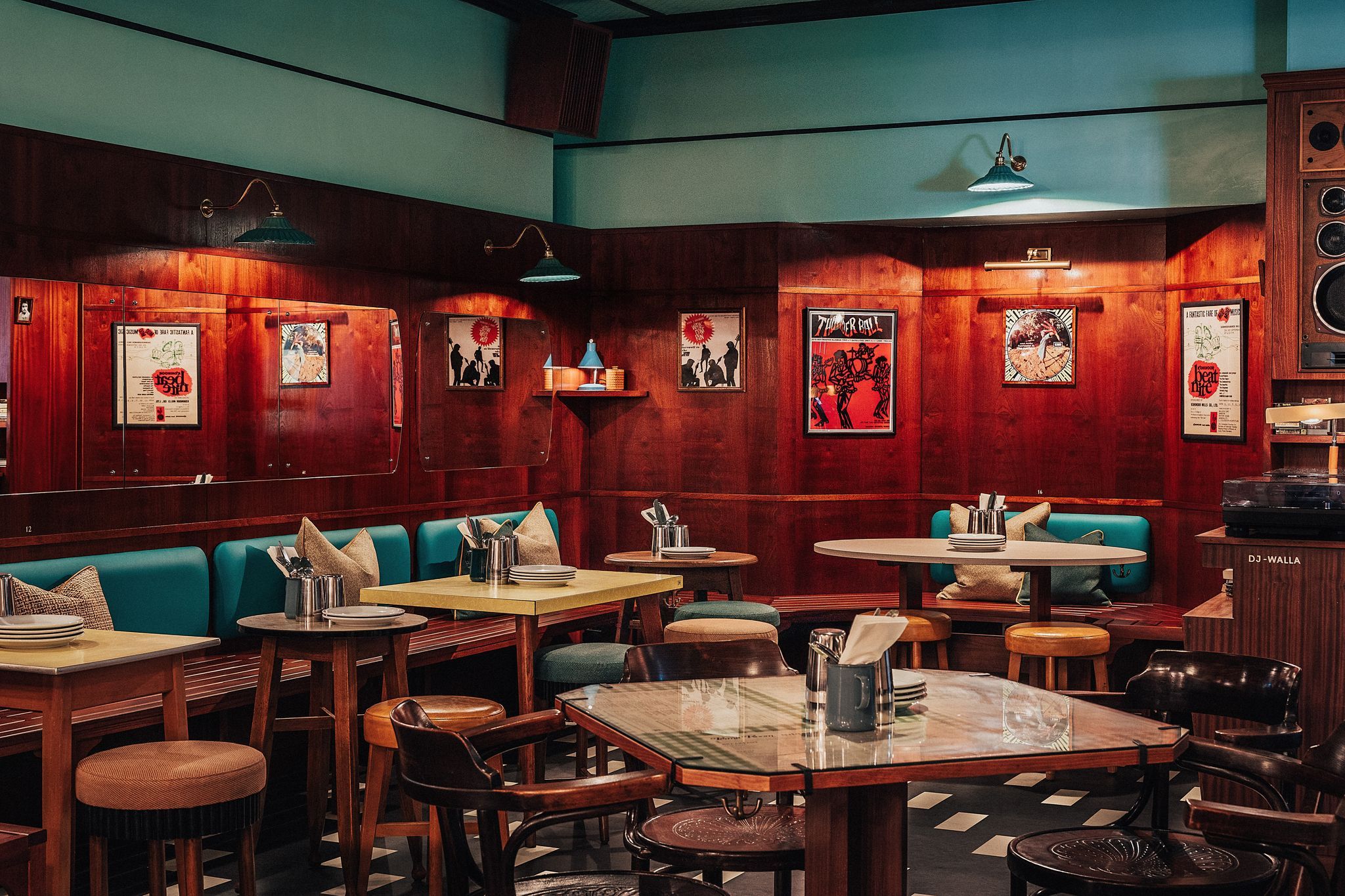 interior shot of the Permit Room Brighton, dining area, brown tables and brown wooden chairs, dark green coloured and wooden walls