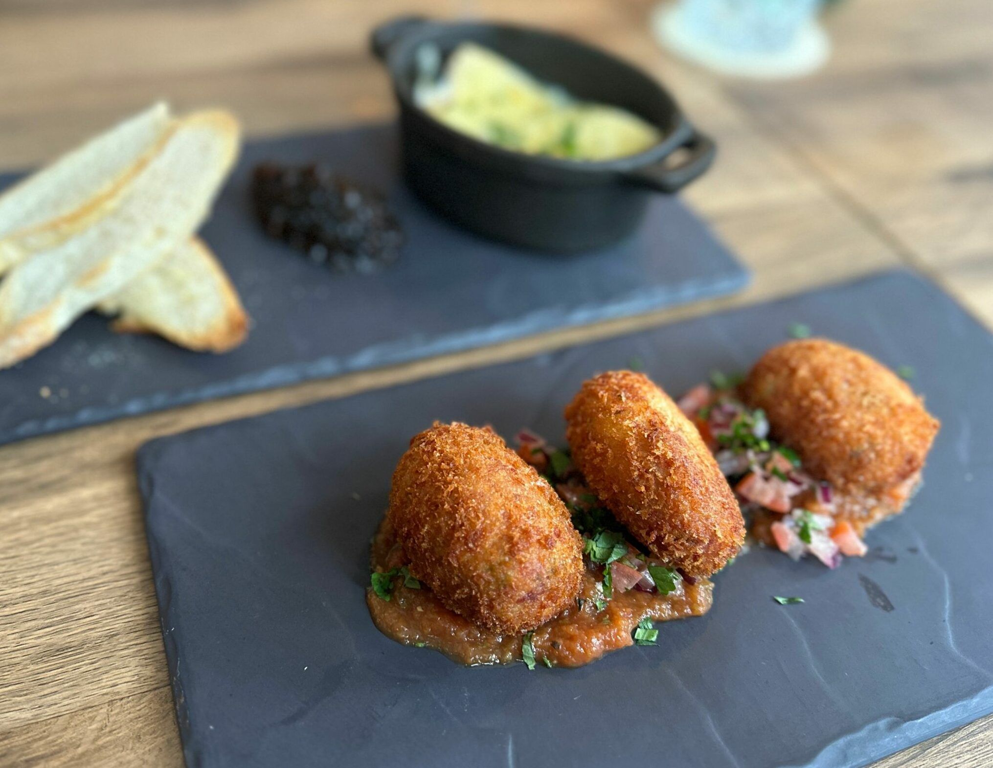 ham hock and cheddar croquettes served on the black board. Autumnal feast at Chimney House