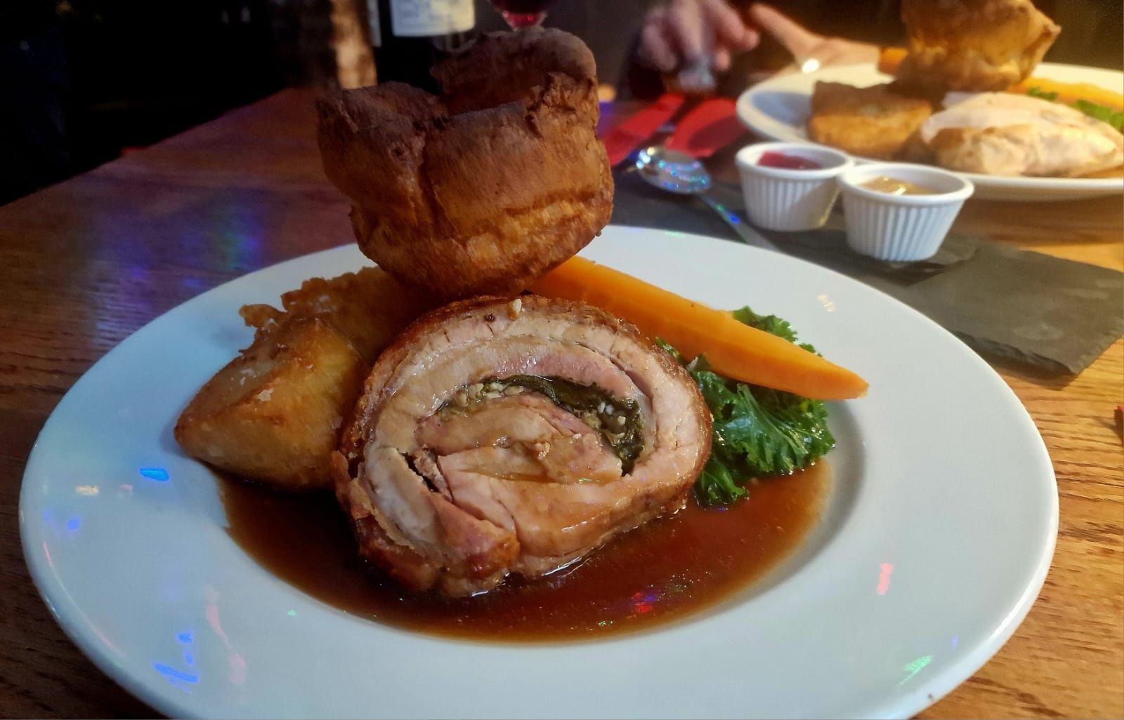 slow cooked porchetta served on the white plate with the Yorkshire pudding. Sunday roast delight at the New Inn 