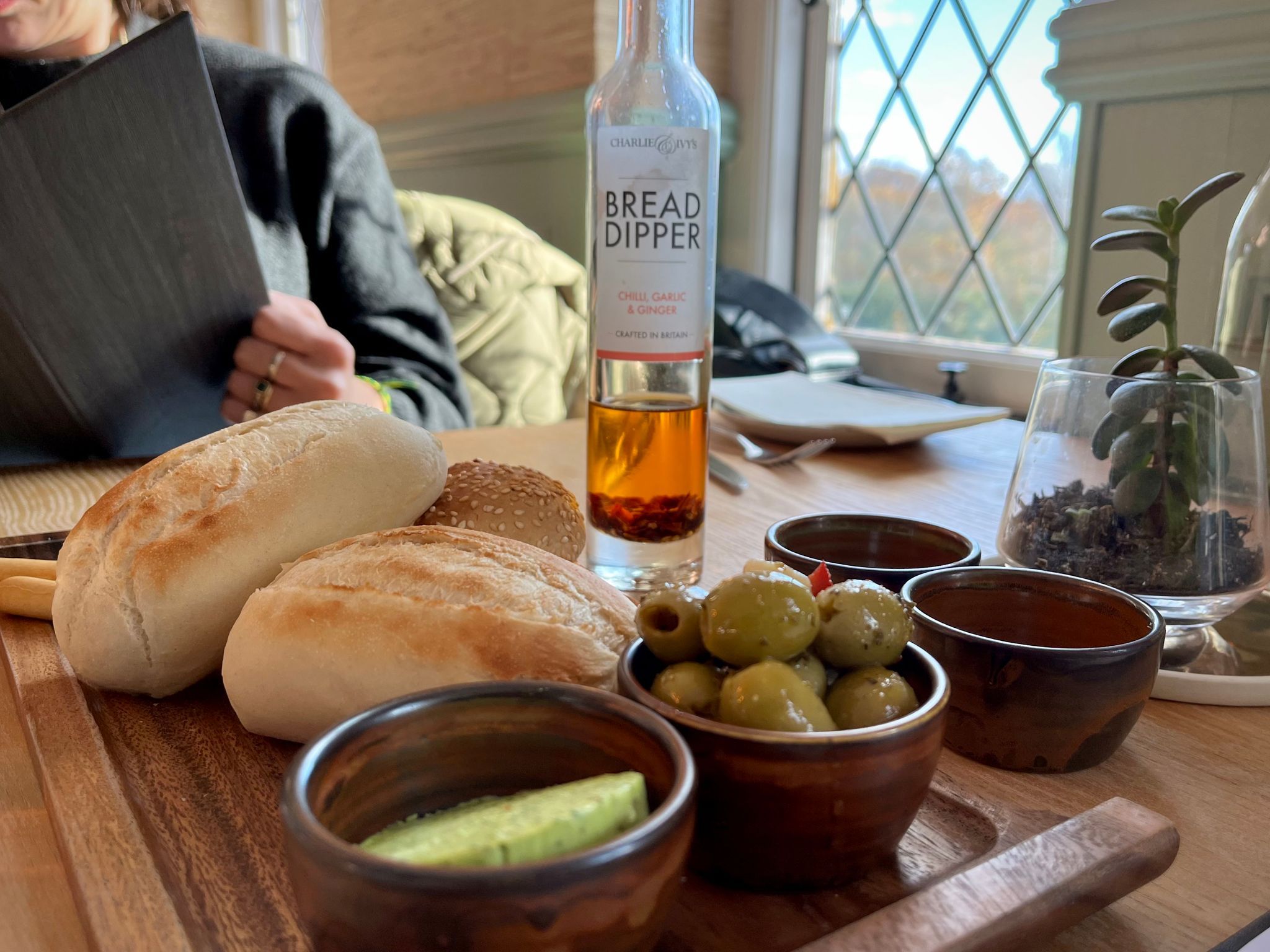 bread and olives served on the wooden board at Mannings Heath. Seasonal lunch at the Sussex wine estate