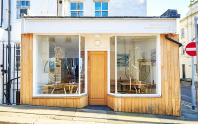 The Little Fish Market restaurant by Duncan Ray - exterior shot. Fish or seafood restaurant in Brighton which is featured in the Michelin guide. Big glass fronted windows with wood panelling exterior giving you a brightly lit restaurant.