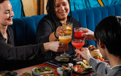 A group of people enjoying happy hour cocktails at food at Blossoms bar in Brighton. Restaurant deals and special offers