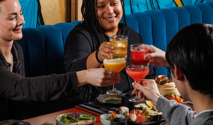 A group of people enjoying happy hour cocktails at food at Blossoms bar in Brighton. Restaurant deals and special offers