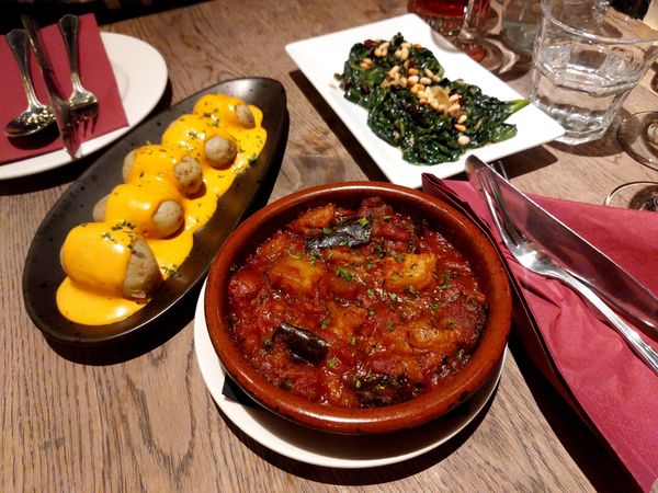 spanish tapas served on brown table with drinks