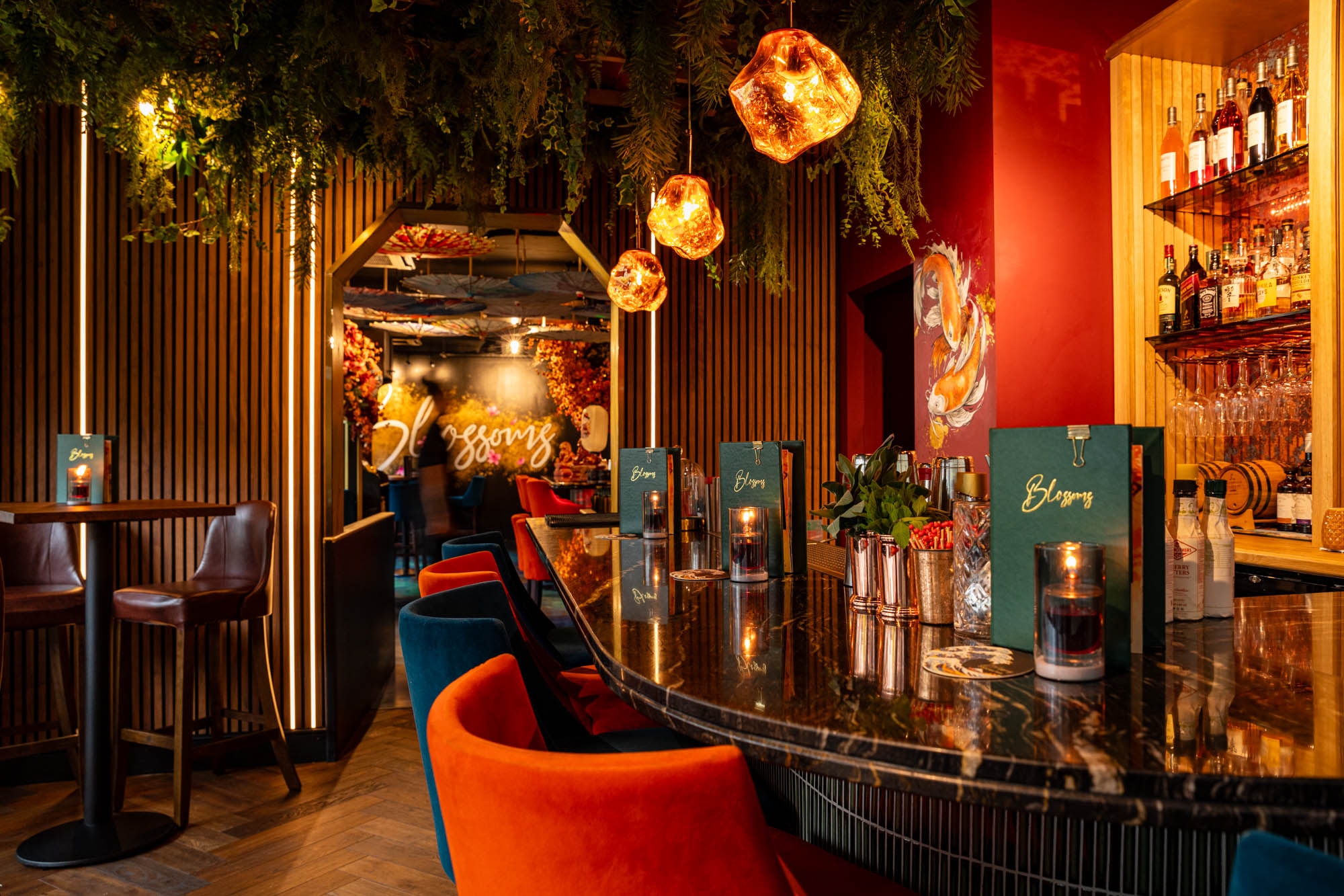 An ambient lit room with bar stools a the bar and green menus sat on the bar.