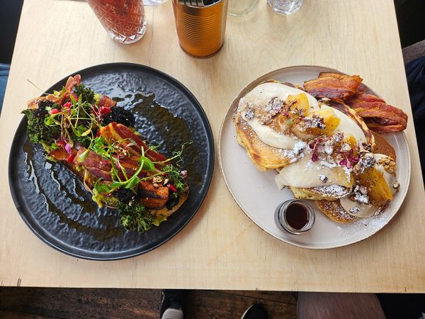 over head shot of the two plates one with delicious pancakes and maple syrup and one with avocado toast. Brunch bliss at Starfish and Coffee